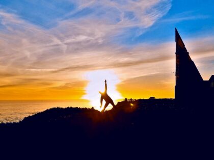 Silhouette of a person in a yoga pose against a sunset