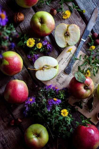 Apples on a table with flowers and sheet music