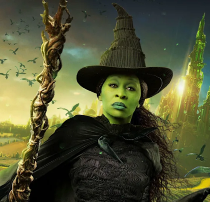 Elphaba from the movie Wicked in black hat, black cape, holding a staff